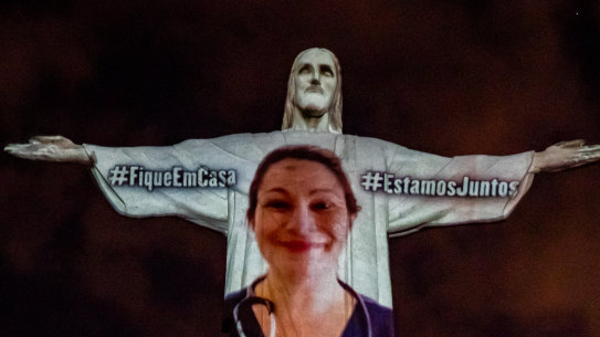View of a medical worker on the illuminated statue of Christ the Redeemer as Archbishop of the city of Rio de Janeiro Dom Orani Tempesta performs a mass on Easter Sunday.