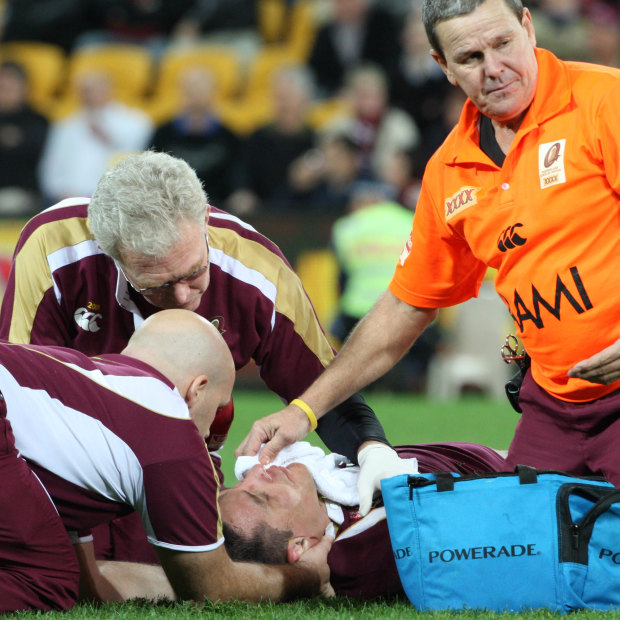 Queensland medical staff attend to Steve Price after he is rocked by Brett White.