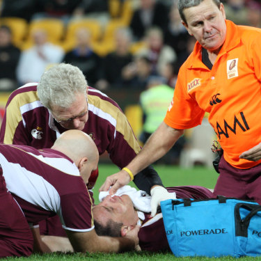 Queensland medical staff attend to Steve Price after he is rocked by Brett White.
