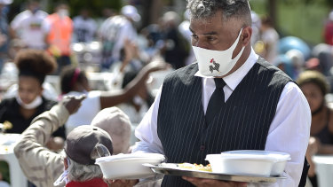 A waiter walks with meals as he serves at the open-air restaurant installed at Praça da Estação for poor residents in Belo Horizonte, Brazil. 