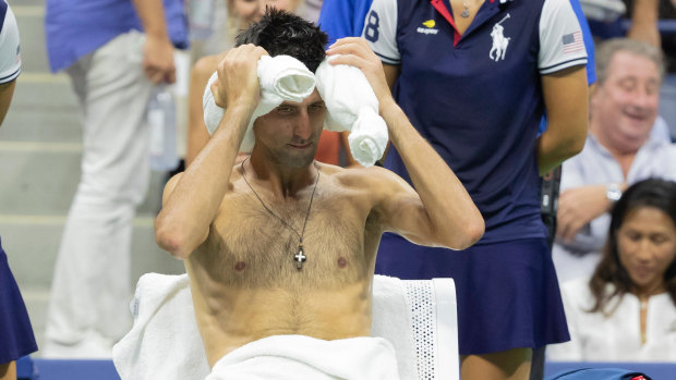 Pre-ice bath: Djokovic uses a "neck sausage" and damp lap towel to cool off during the US Open in 2018.