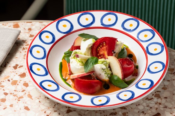 Mussarela de búfala com tomate Noosa Reds, pêssegos, manjericão e vinagre balsâmico envelhecido.