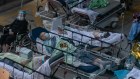 Patients with COVID-19 symptoms wait at a temporary holding area outside Hong Kong’s Caritas Medical Centre on Tuesday.