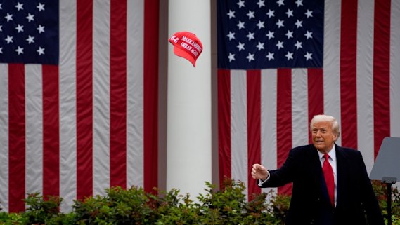 US President Donald Trump tosses a “Make America Great Again” hat during his tariff announcement in the Rose Garden of the White House on Wednesday.