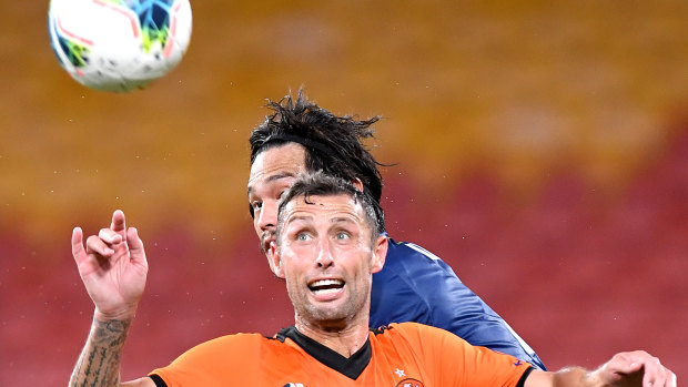 Scott McDonald of the Roar and Eunsun Kim of the Mariners challenge for the ball.