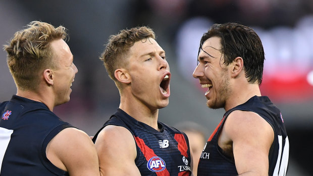 Giant killers: James Harmes, Jake Melksham and Michael Hibberd celebrate after the Melbourne go further ahead against GWS during their round 23 clash at the MCG.