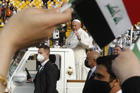 Pope Francis waves as he arrives for an open air Mass at a stadium in Erbil, Iraq.