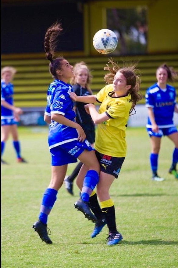 Christina Stefanou (blue jersey), 16, playing soccer shortly before she was diagnosed with post-concussion syndrome and forced to give up the sport.