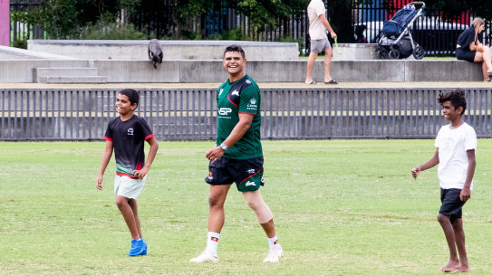 Rabbitohs star Latrell Mitchell back at training on Monday, sharing a laugh with two visiting children.
