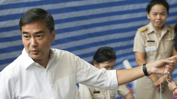Democrat Party leader Abhisit Vejjajiva gestures as he arrives at a polling station to cast his ballot in Bangkok , Thailand, on Sunday.