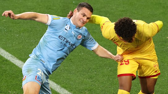 Curtis Good of Melbourne City and Kusini Yengi of Adelaide United compete for the ball.