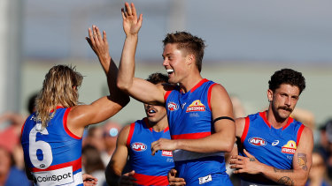 Josh Schache celebrates a goal with Bailey Smith and Tom Liberatore.