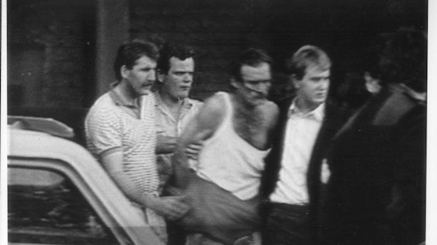 Cox (in singlet) during his arrest in 1988.