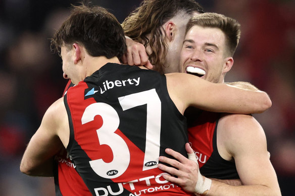 Essendon players celebrate on the final siren.