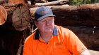 Jay Branson, owner of the Dwellingup Sawmill, sitting among some of the last commercially harvested Jarrah logs in WA.