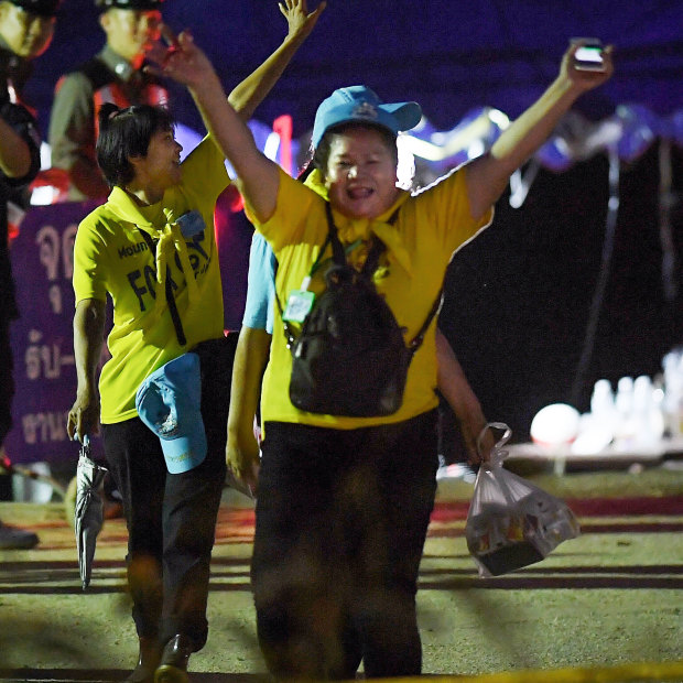Thai volunteers cheer and yell "hooray" as they return from Tham Luang cave after the group was rescued. 