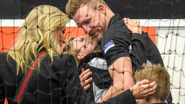 Collingwood coach Nathan Buckley being comforted by his family after the Pies loss.