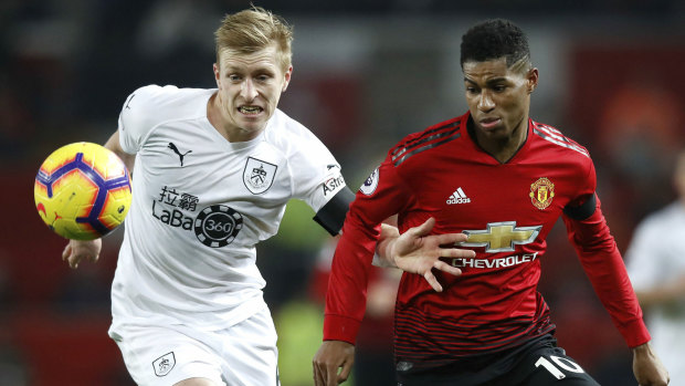Burnley's Ben Mee (left) competes with Manchester United's Marcus Rashford.
