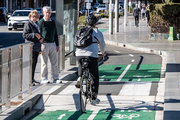 Kathryn Greiner and Michael Waterhouse at an island bus stop with a separated cycleway outside Waverley Bus Depot on Oxford Street in Bondi Junction.
