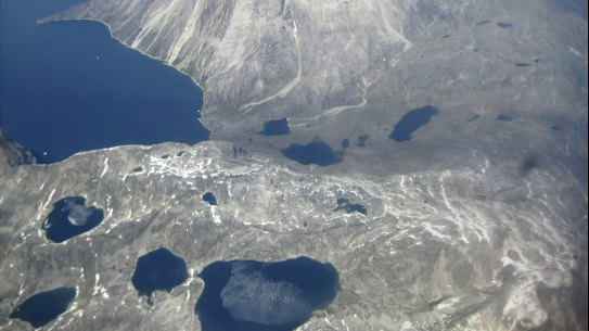 An aerial view of melt-water lakes on the edge of an ice cap in Nunatarssuk, Greenland, taken in June 2019.