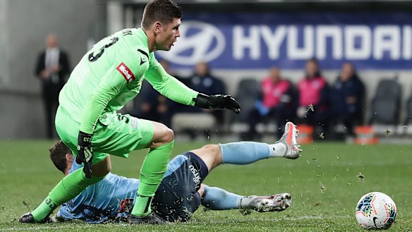 Sliding doors: Sydney FC striker Adam Le Fondre slides in on Perth goalkeeper Liam Reddy to score last night. 