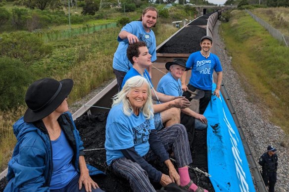 A group of people sat on top of the open coal carriage as police watched on.