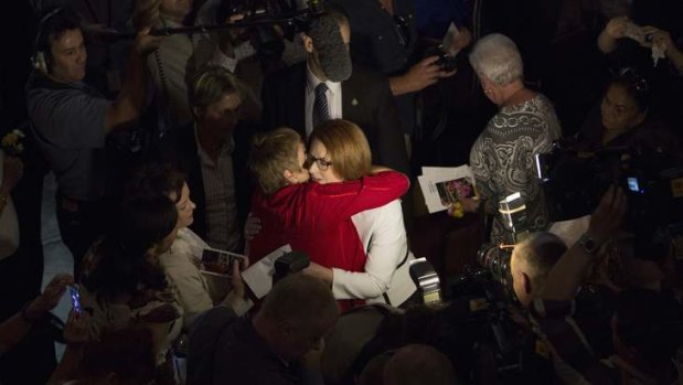 Julia Gillard embraces members of the audience after the National Apology for Forced Adoptions.
