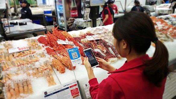 Shoppers use Alipay at Nicholas Seafood to place their order and pay from their phones. 