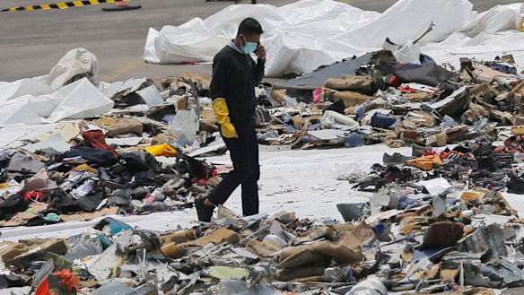 An investigator walks amid debris of Lion Air Flight 610 retrieved from the waters off Tanjung Priok in Jakarta.