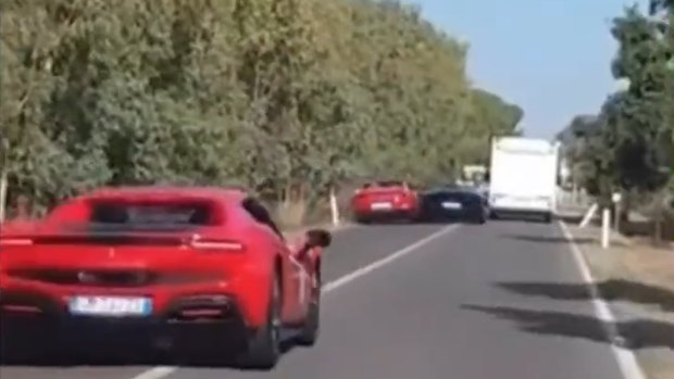 Video footage by the dashcam of another car shows the red car and the blue Lamborghini trying to overtake a large white campervan.