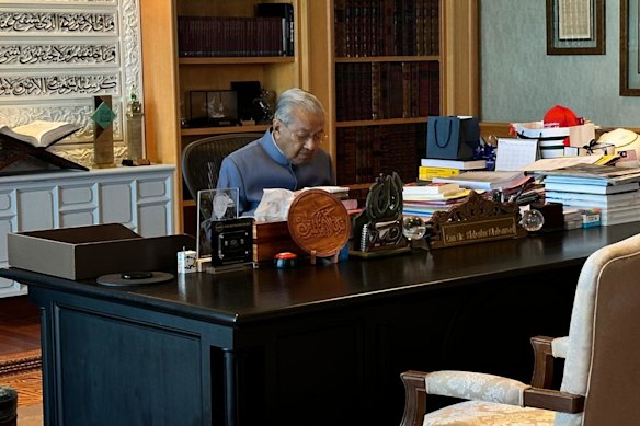 Former Malaysian Prime Minister Mahathir Mohamed works in his office on his 100th birthday.