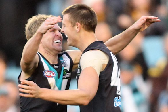Kane Cornes (left) and Daniel Stewart embrace as Power teammates in 2010.