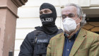 Masked police officers lead Heinrich XIII Prince Reuss, centre, to a police vehicle during a raid against the coup plotters in Germany.