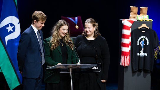Surrounded on stage by items from his life, Richard Scolyer’s children - Matthew,20, Emily, 22, and Lucy, 18 - deliver a joint eulogy at the service.