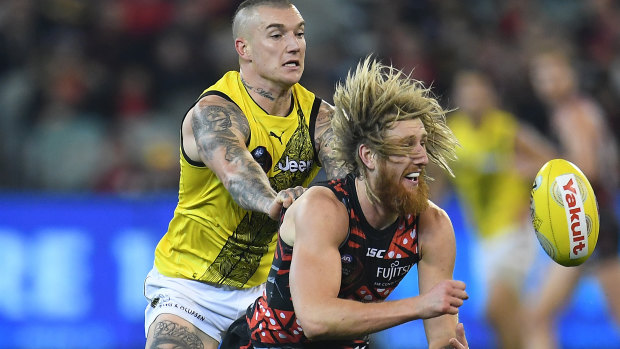 Tigers star Dustin Martin bears down on Bombers captain Dyson Heppell.