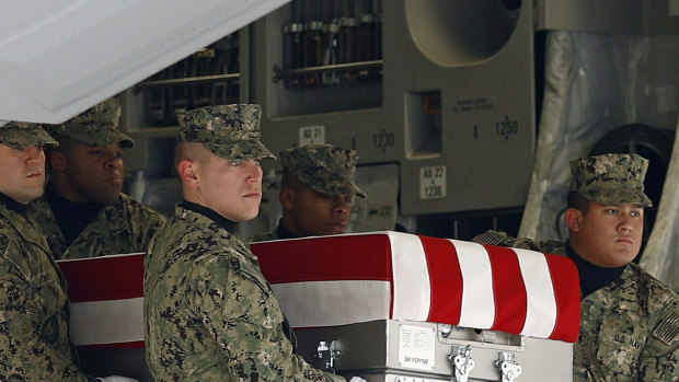 A US Navy  team on Saturday moves a transfer case containing the remains of a serviceman killed  in last week's suicide bomb attack in Manbij, Syria. 