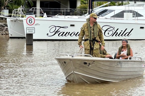 Defence Force personnel help out in evacuations following flooding in Cairns.