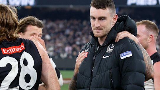 Dan McStay is consoled by teammates after Collingwood’s preliminary final victory.