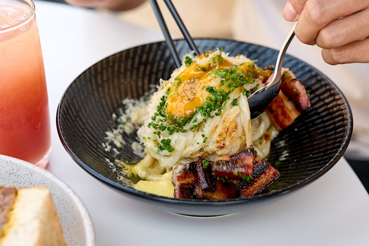 Udon carbonara with charred kaiserfleisch, a soft egg and pepper. 