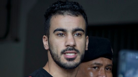 Bahraini football player Hakeem al-Araibi, left, gestures as he is brought in to a court in Bangkok, Thailand, Tuesday, Dec. 11, 2018.