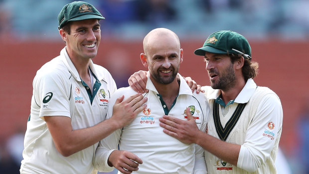 Nathan Lyon celebrates with Pat Cummins and Joe Burns after taking the wicket of Shaheen Shah Afridi.