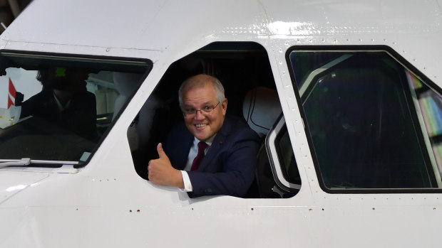 Prime Minister Scott Morrison leaning out of a Qantas plane on Thursday ahead of announcing the $1.2 billion industry package. 