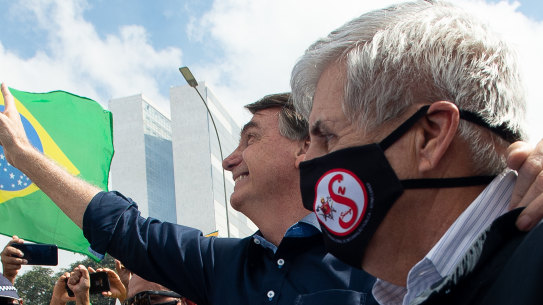 Brazilian President Jair Bolsonaro and Secretary of Institutional Security and Brazilian Army General Augusto Heleno wave to supporters.