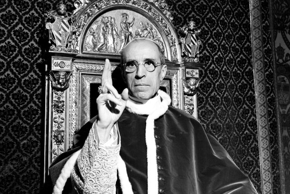 Pope Pius XII, wearing the ring of St Peter, sits on his throne at the Vatican in September 1945.