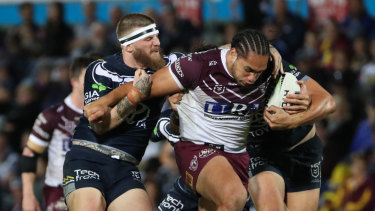 Leg drive: Josh McGuire of the Cowboys hangs onto Martin Taupau.