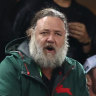 Russell Crowe in the stands at a Souths game with fellow Hollywood stars Chris Hemsworth and Jeff Goldblum in the background.