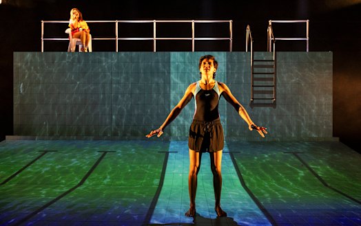 The set is a vast white tiled swimming pool onto which are projected images: Swim.