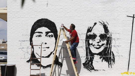 Manuel Oliver works on a mural in El Paso, Texas. It reads: The Americas belong to everyone". The shooting that killed 20 people on Saturday is being handled as a domestic terrorism case.
