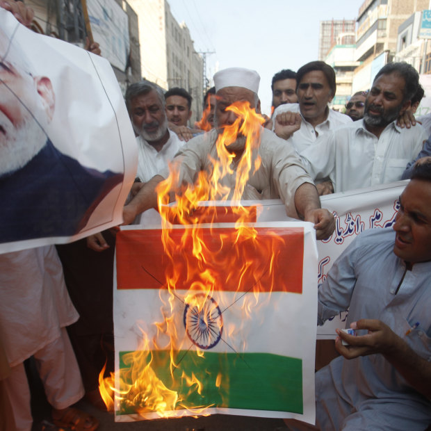 Pakistanis burn an Indian flag in protest over the Kashmir decree.