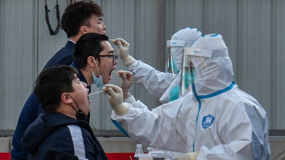 Health workers test residents in Beijing.